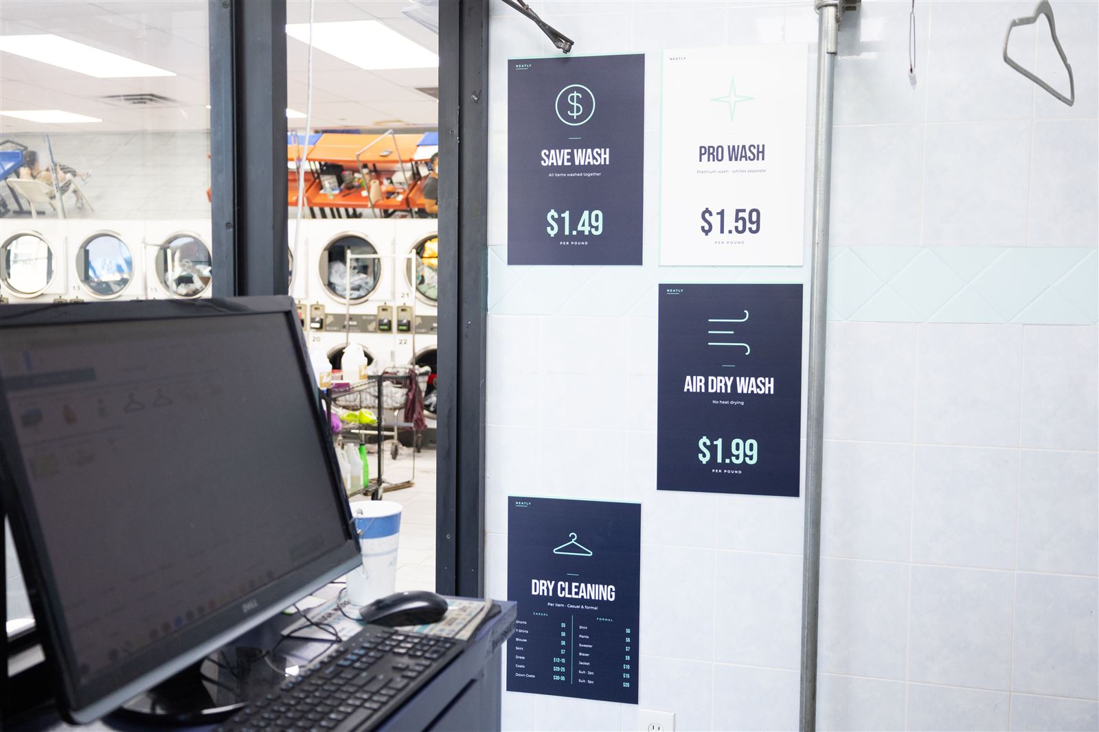 Wash and fold and dry cleaning price signs at the Neatly counter, 2333 Hylan Blvd