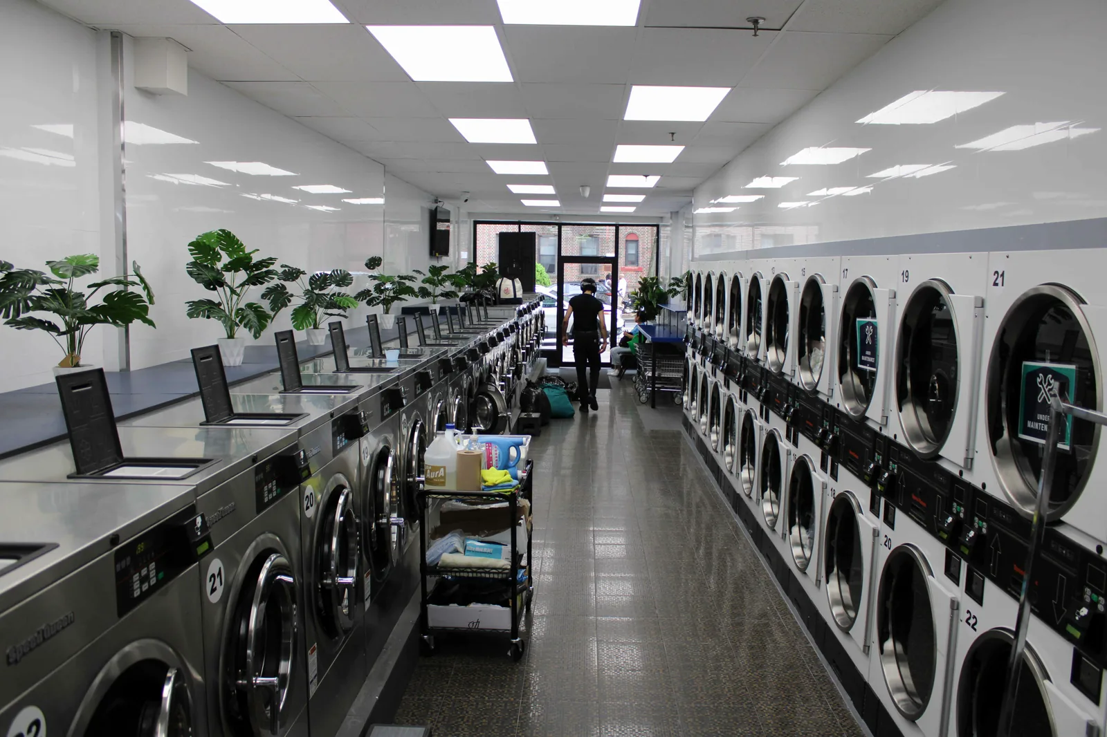 Bright main aisle with washers on the left and dryers on the right at Neatly, 37 Lincoln Rd, Brooklyn