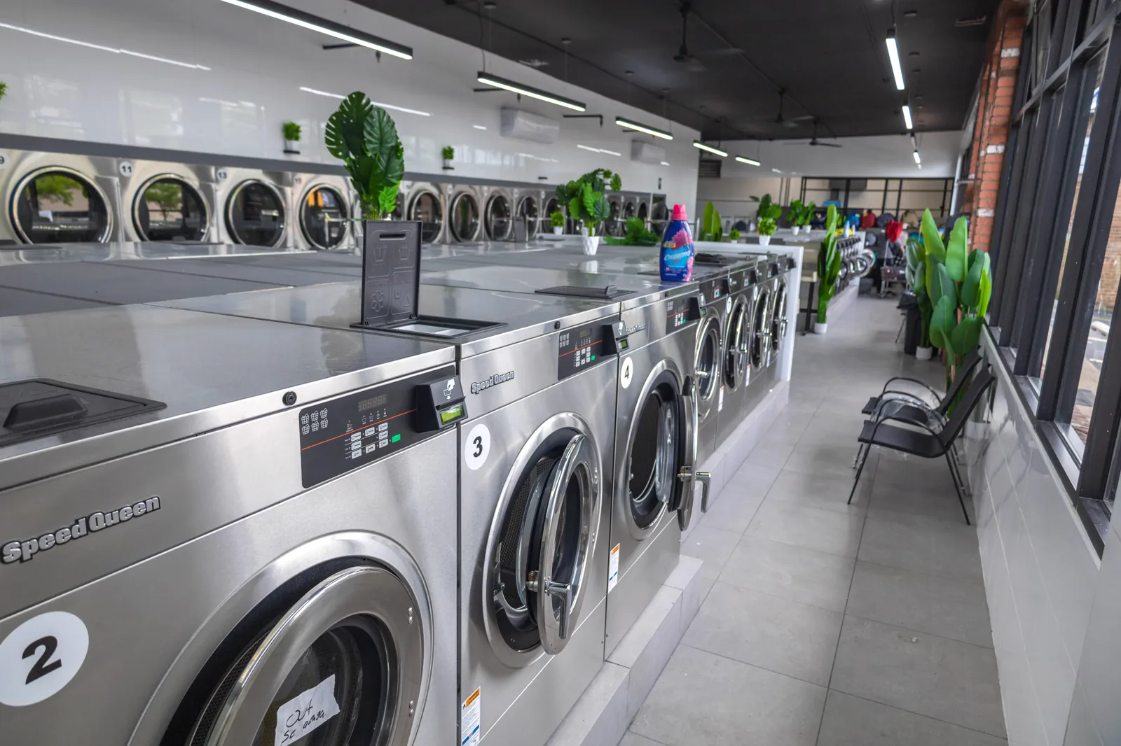 Row of Speed Queen front-load washers and dryers inside Neatly, 1936 Victory Blvd
