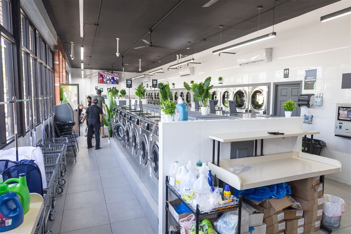 Washers, folding station and detergent shelf inside Neatly Laundromat at 1936 Victory Blvd, Staten Island